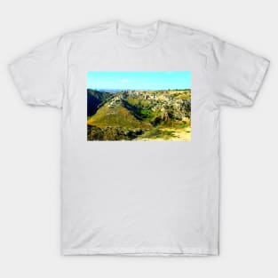 Rocky canyon partly covered with green grass and randomly placed shrubs near Matera T-Shirt